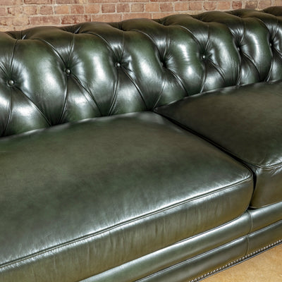 Verde Sovereign western sofa close-up showing deep button tufting, generous leather seat cushions, piping, and rich green tone