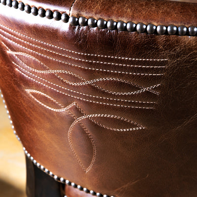 Detailed view of boot stitch embroidery on the back of a brown Western leather bar stool