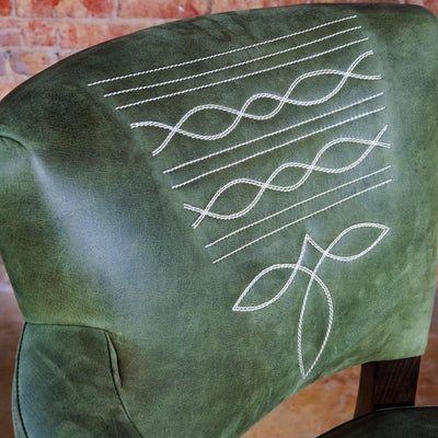 Close-up of Western boot stitch embroidery on olive green leather bar stool backrest