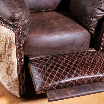 Close-up of brindle cowhide and antique nailhead detailing on leather recliner