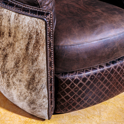 Close-up of brindle cowhide and antique nailhead detailing on leather recliner