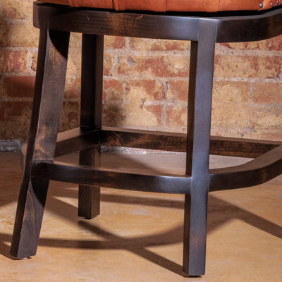Curved-back Western leather bar stool with nailhead trim and walnut legs