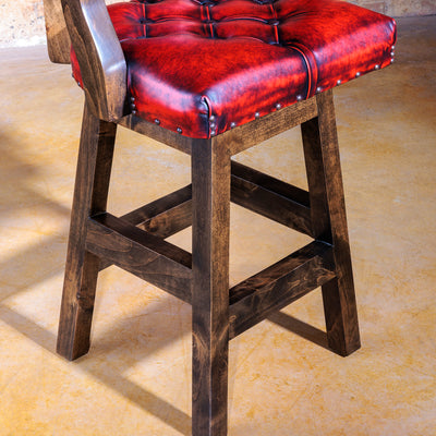 Deep tufted leather backrest and solid wood legs in profile