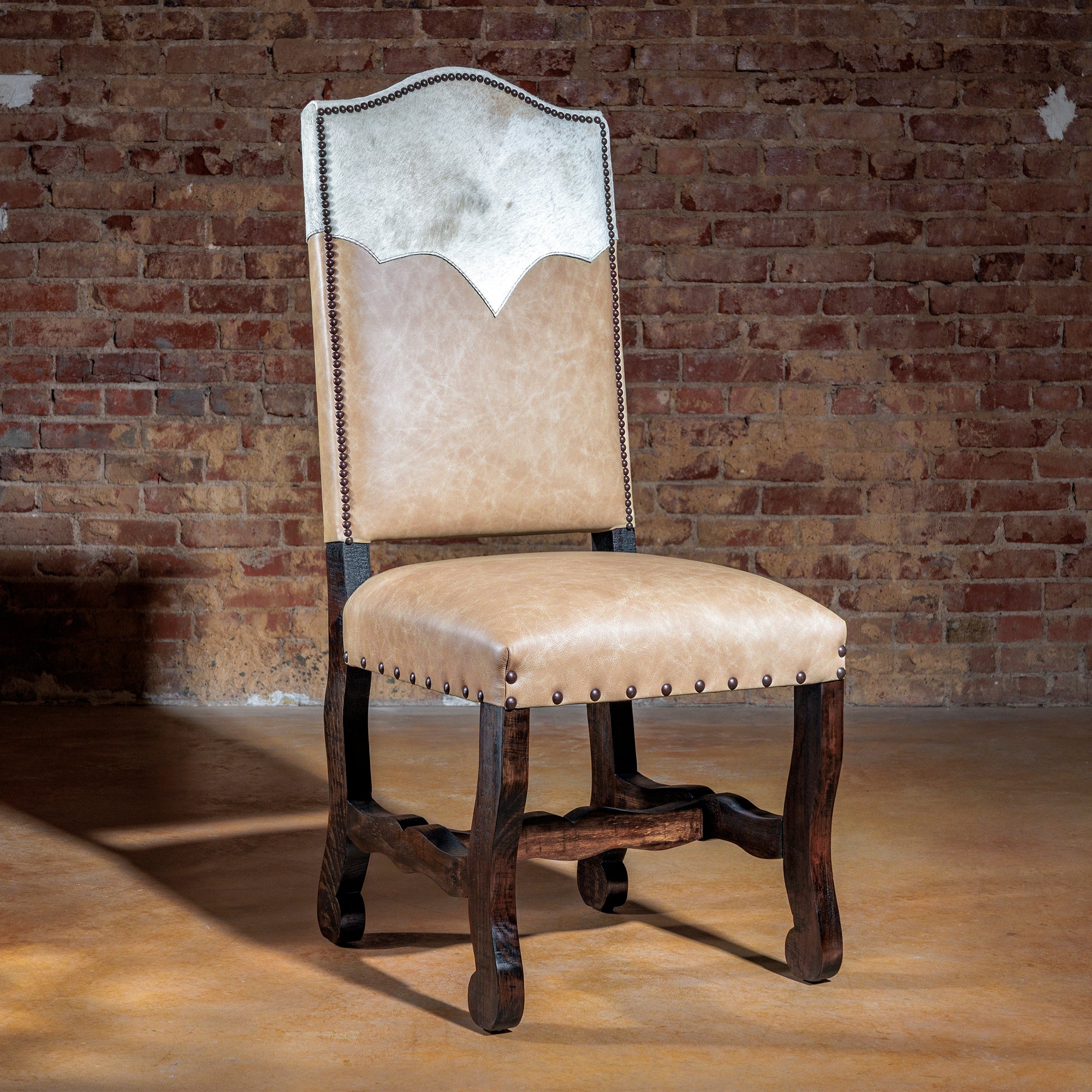 Front view of Western cream cowhide yoke dining chair with leather seat and nailhead trim