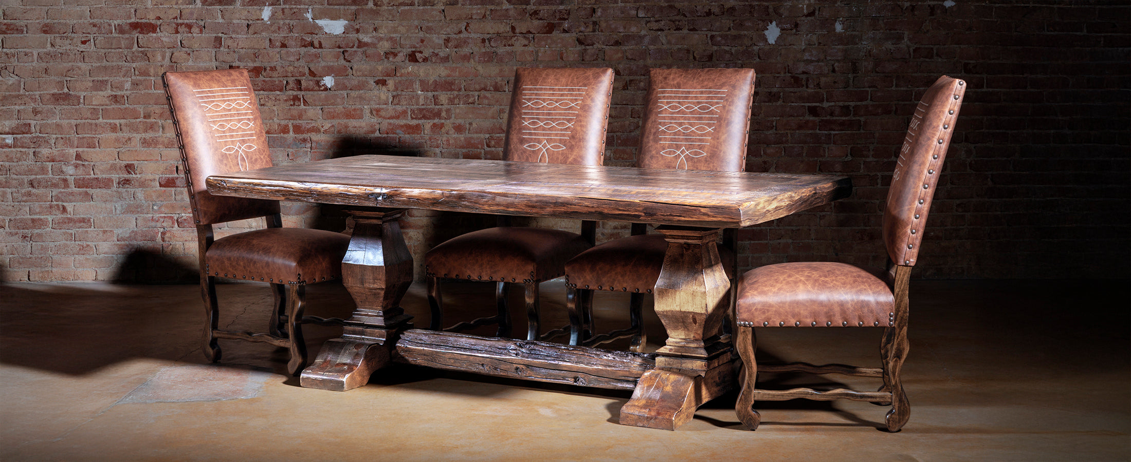 Western wooden dining table with intricate carvings and chairs in a rustic setting.