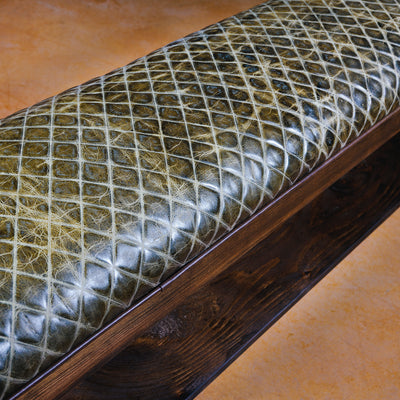 Close-up of embossed leather seat on handcrafted ranch-style bench