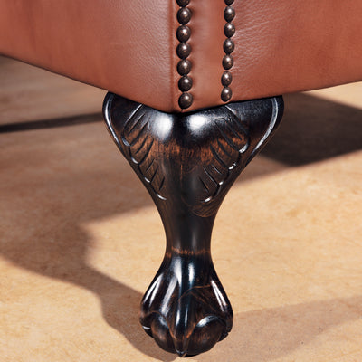 Carved clawfoot legs on Western leather wingback chair with rustic finish