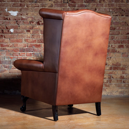 Back view of leather Western chair featuring detailed white cowboy
