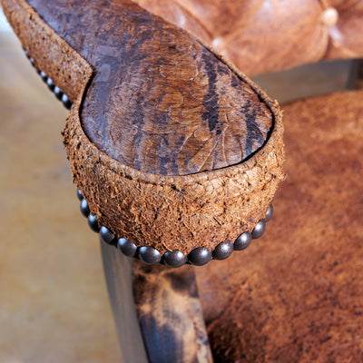 Close-up of tufted leather armrest on handcrafted Western bar stool