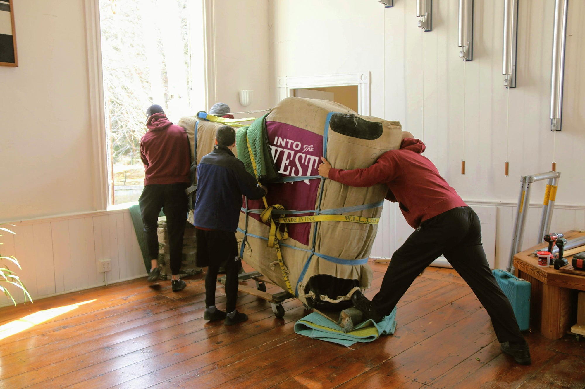 White-glove delivery team carefully placing heirloom Western furniture in a ranch home.